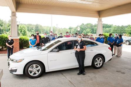 A Commonwealth Senior Living associate receiving help, surrounded by colleagues